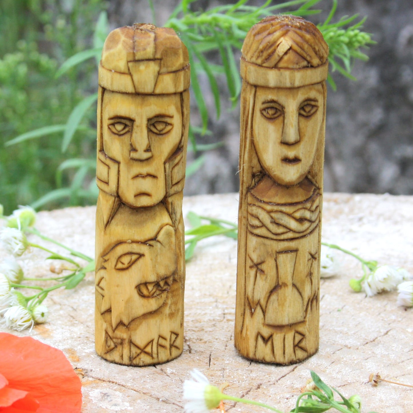 Eir and Vidar 10 cm wooden figurines on a natural surface with flowers.