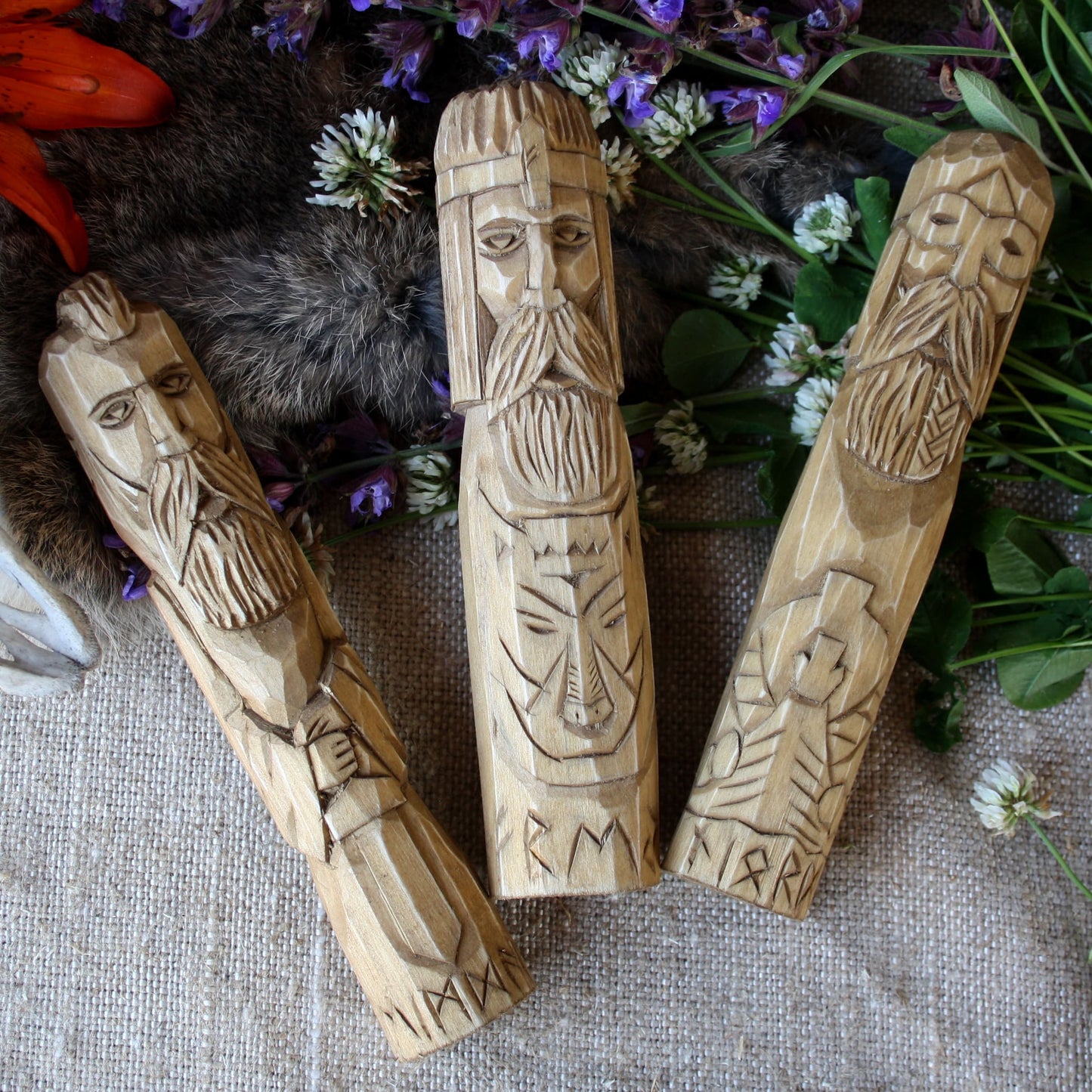 Njord wooden statue 18 cm hand carved figurine with other Norse Gods on a textured surface with flowers and leaves.