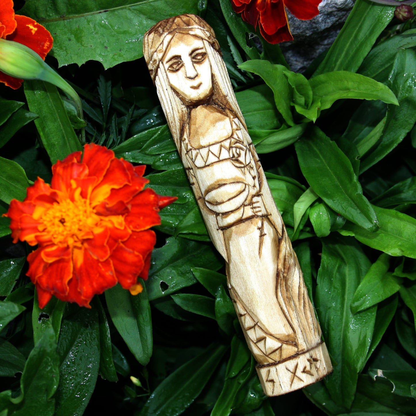 Sigyn wooden statue 15 cm on a bed of green leaves and orange flowers