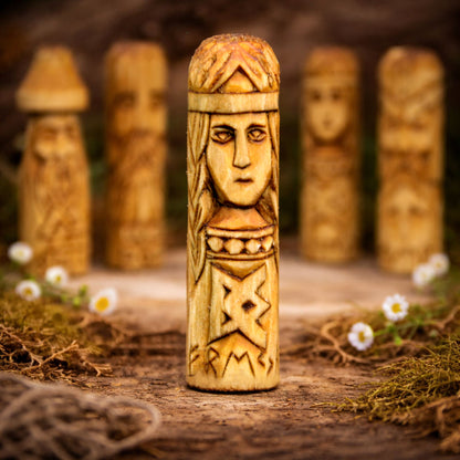 Carved wooden figure of Goddess Freya with intricate patterns on a natural background