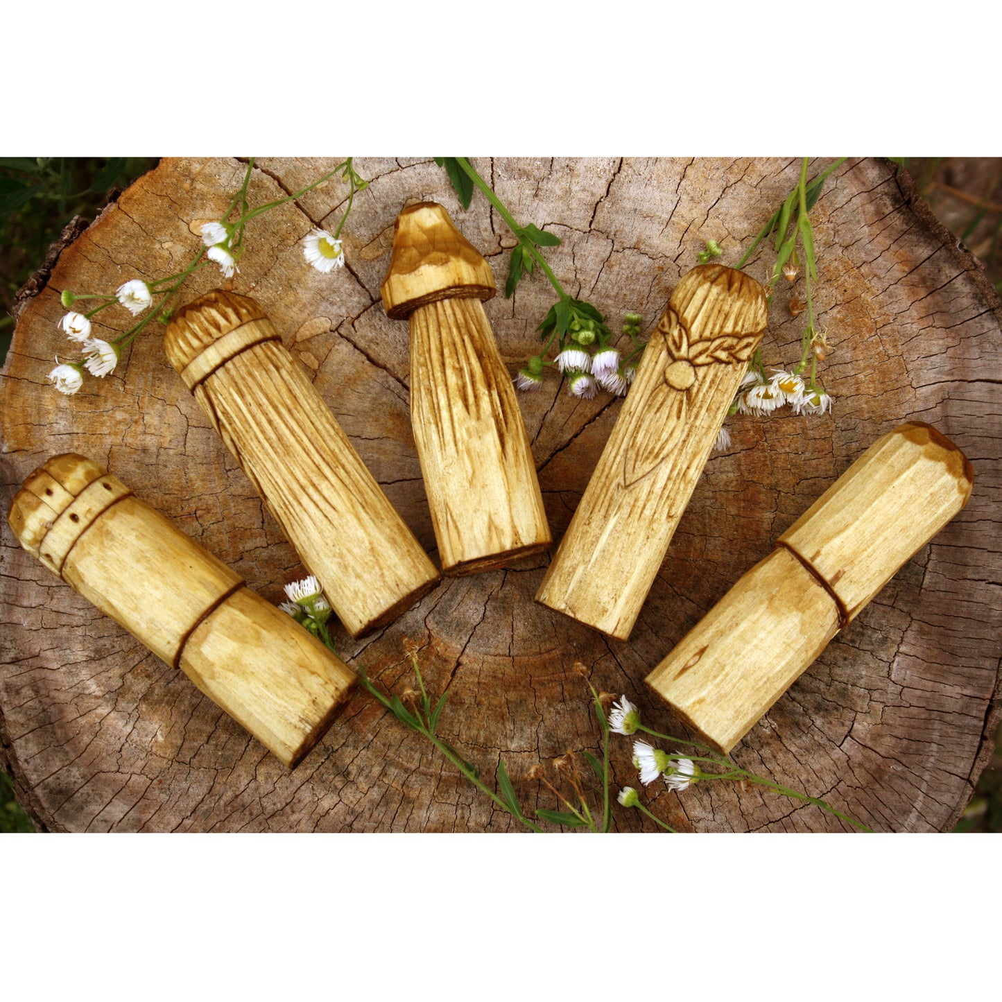 Wooden mushroom-shaped objects on a wooden surface with flowers.