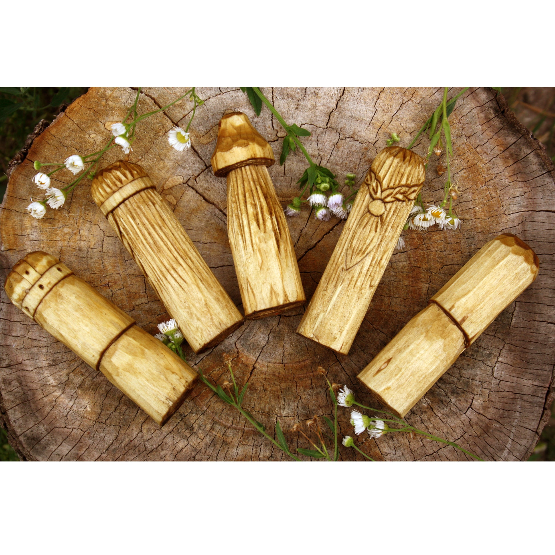 Wooden mushroom-shaped objects on a wooden surface with flowers.