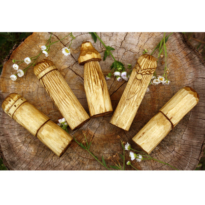 Wooden mushroom-shaped objects on a wooden surface with flowers.
