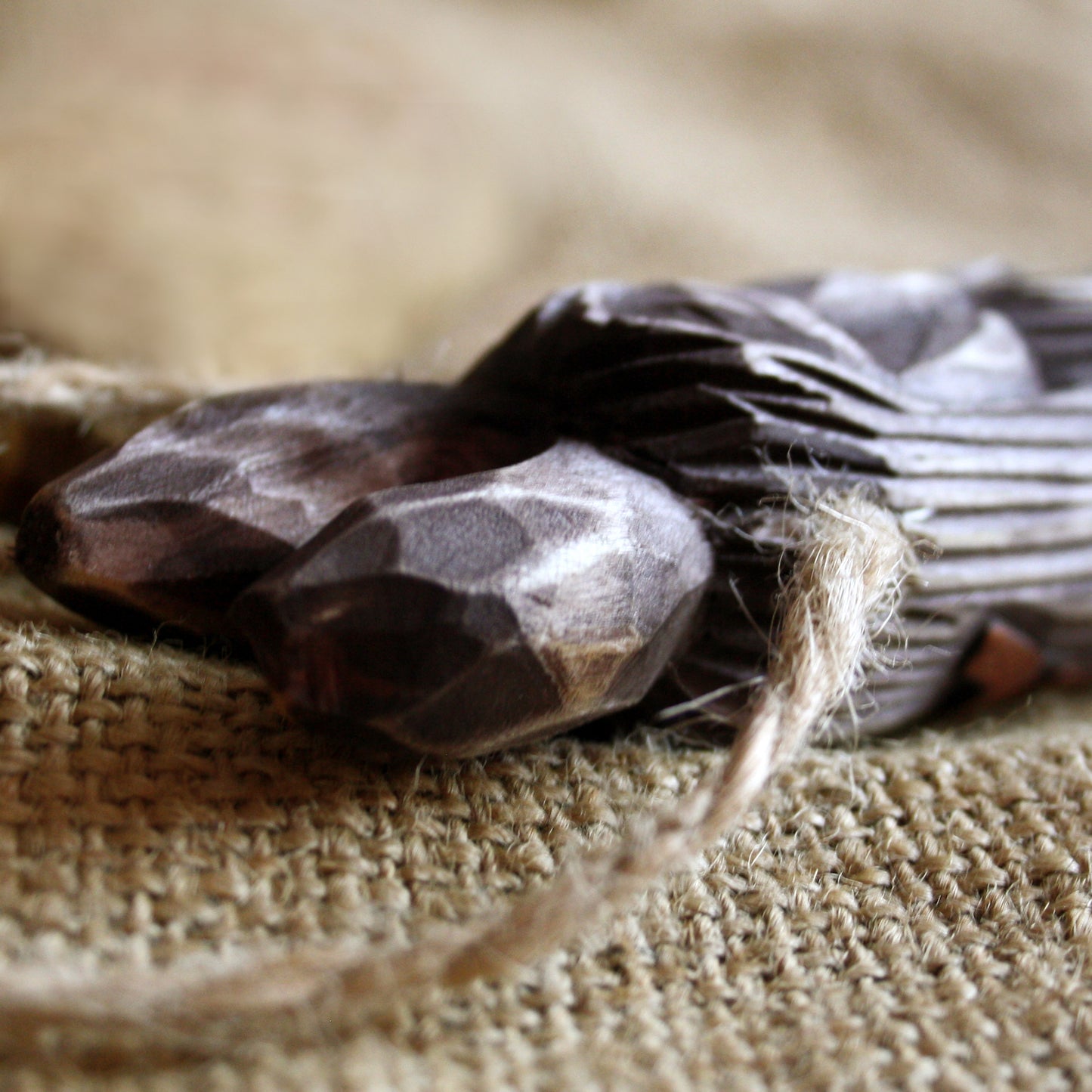 Close-up of a dark brown stone on a textured surface with a blurred background