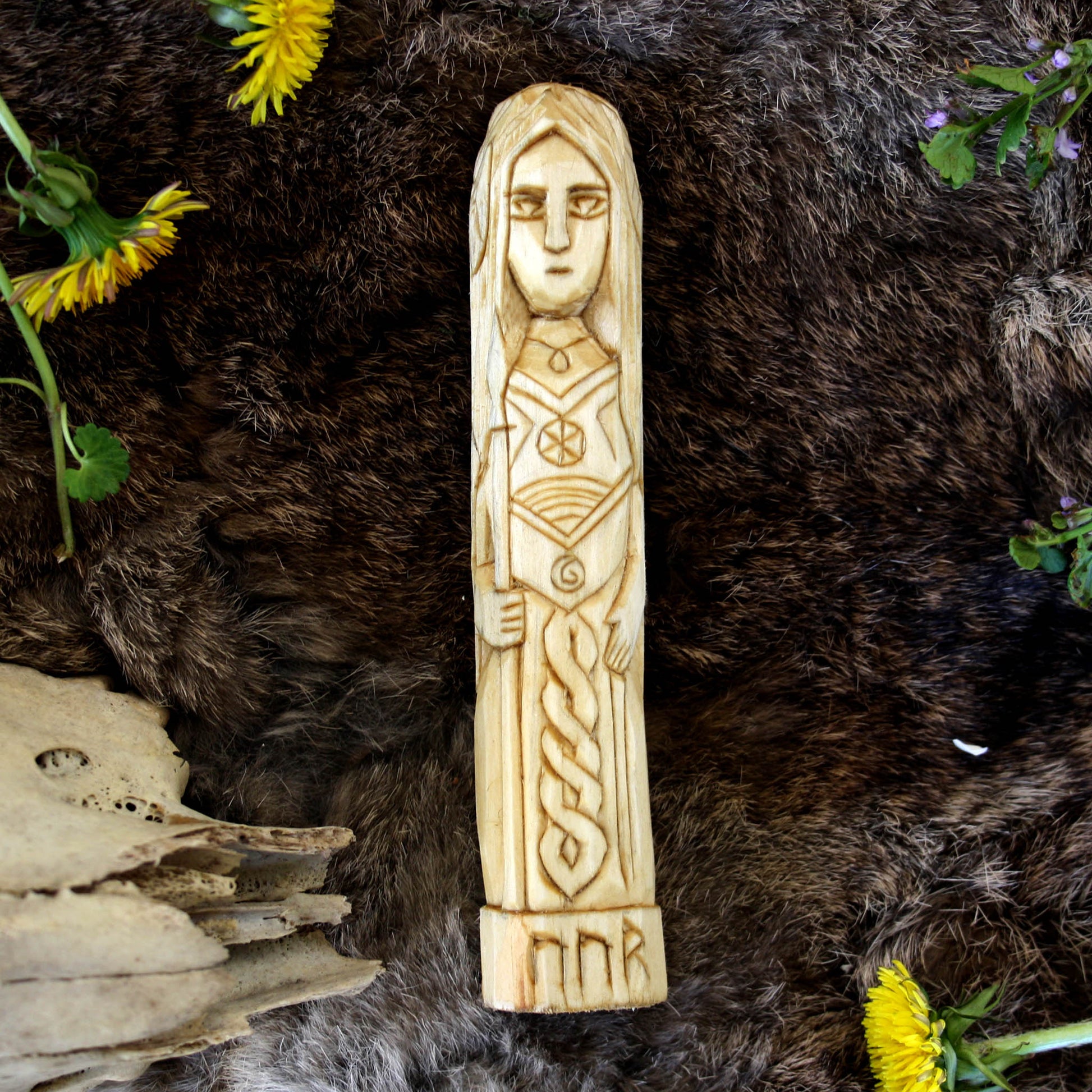 Vor wooden statue 15 cmon a textured surface with flowers