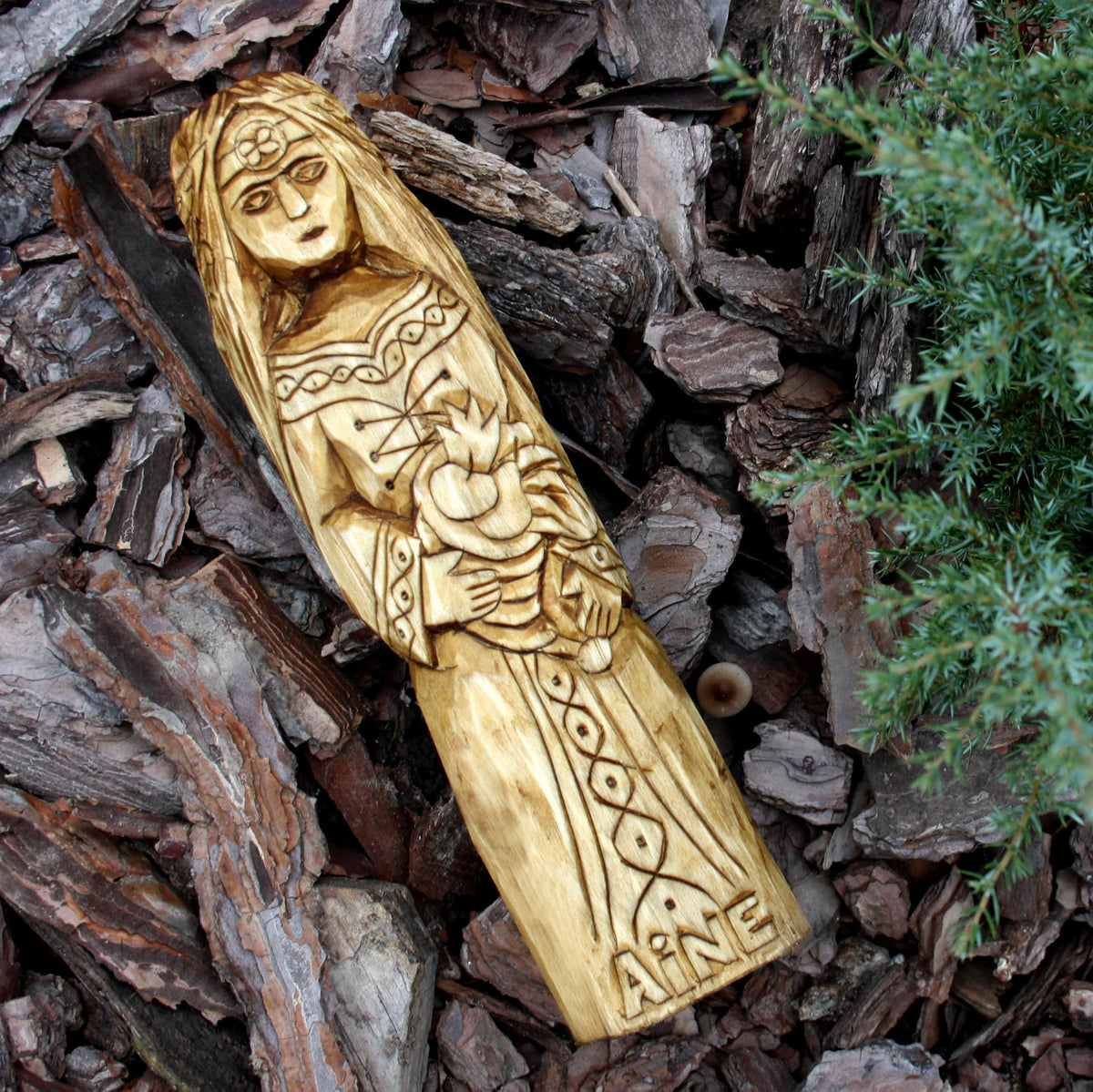 Hand-carved Áine statue displayed outdoors against a natural background