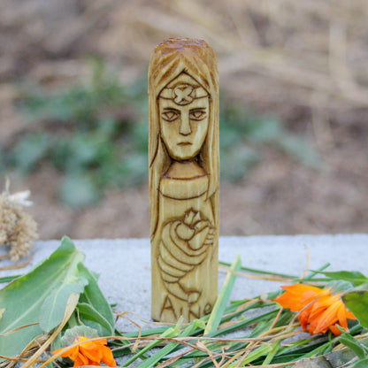 Small wooden Áine goddess figurine with flowing hair and decorative carving
