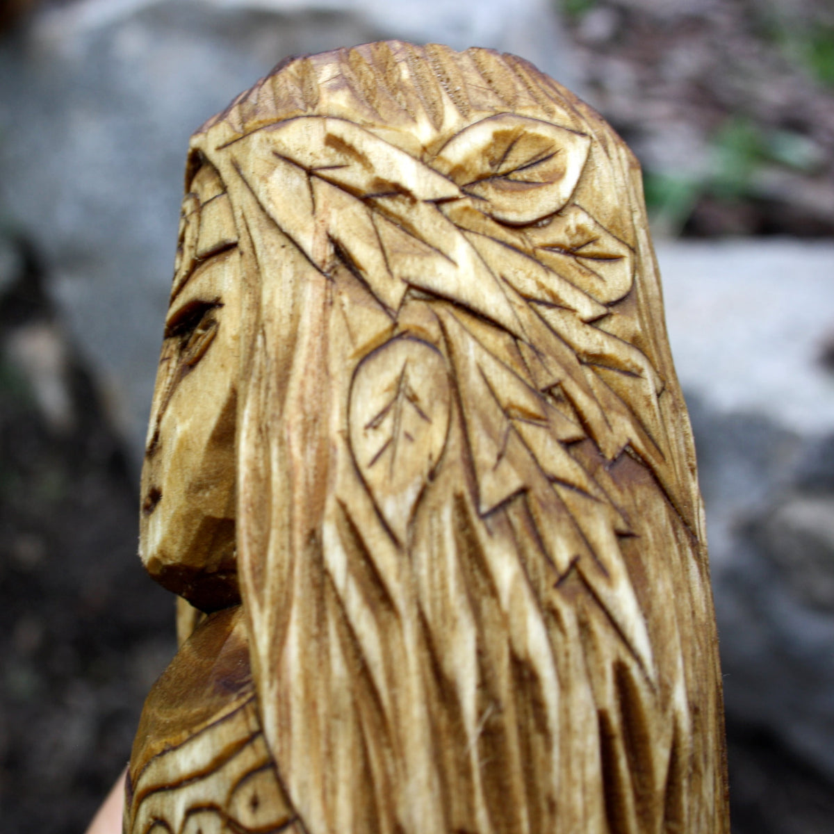 Close-up of the long carved hair and textured details on the back of the Áine statue