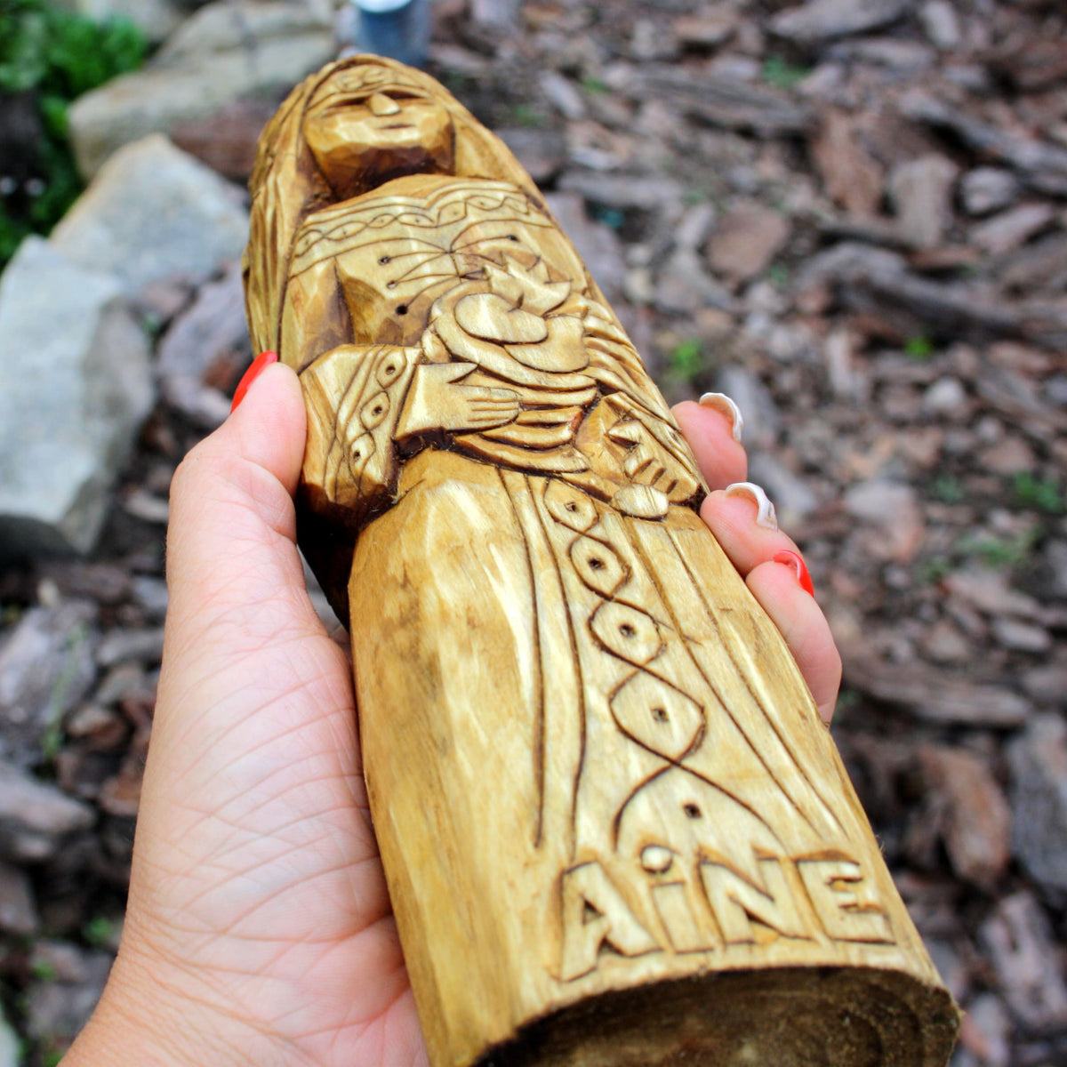 Close-up of the Áine wooden figure highlighting its carved clothing and ornament