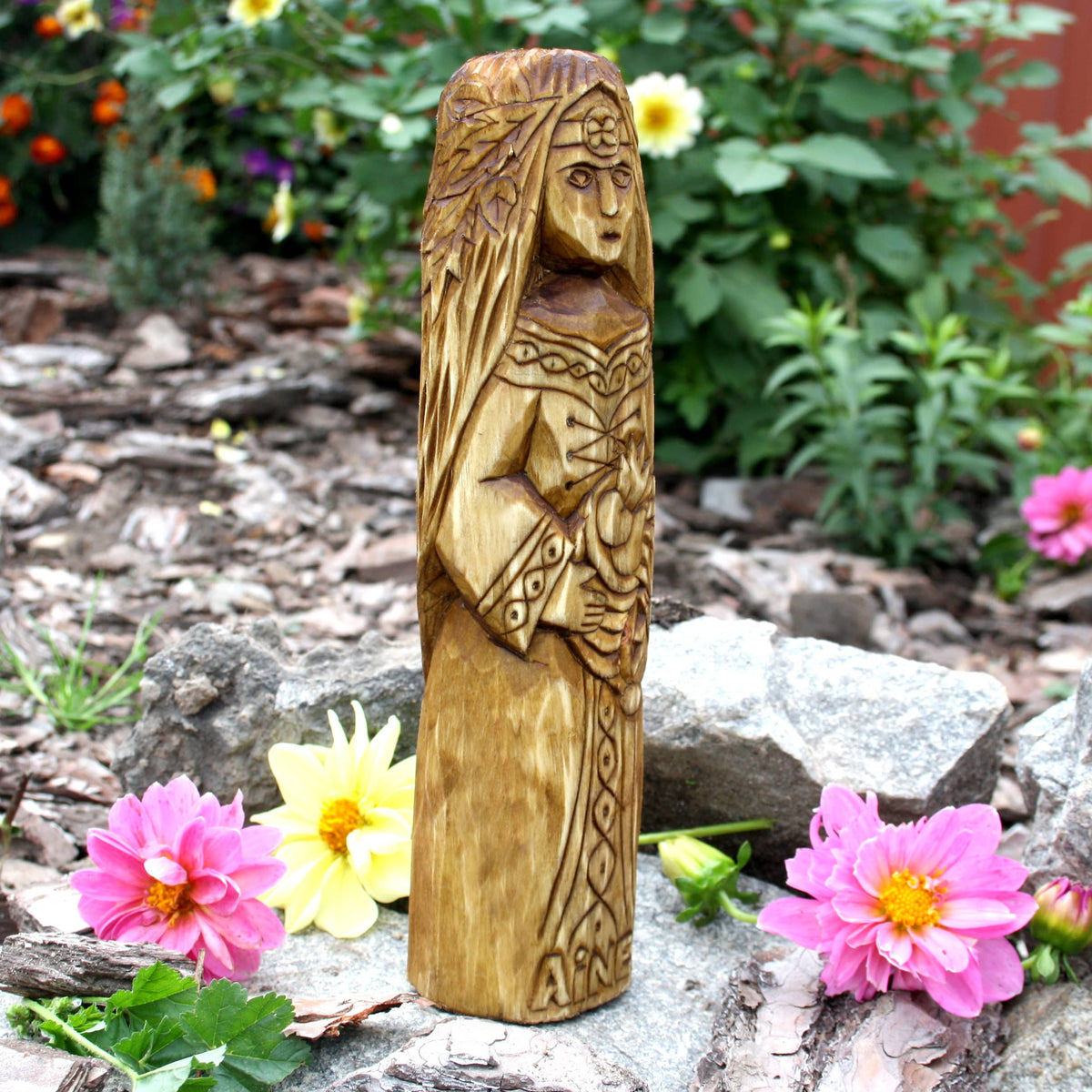 Side view of the Áine wooden sculpture showing the carved hair and figure