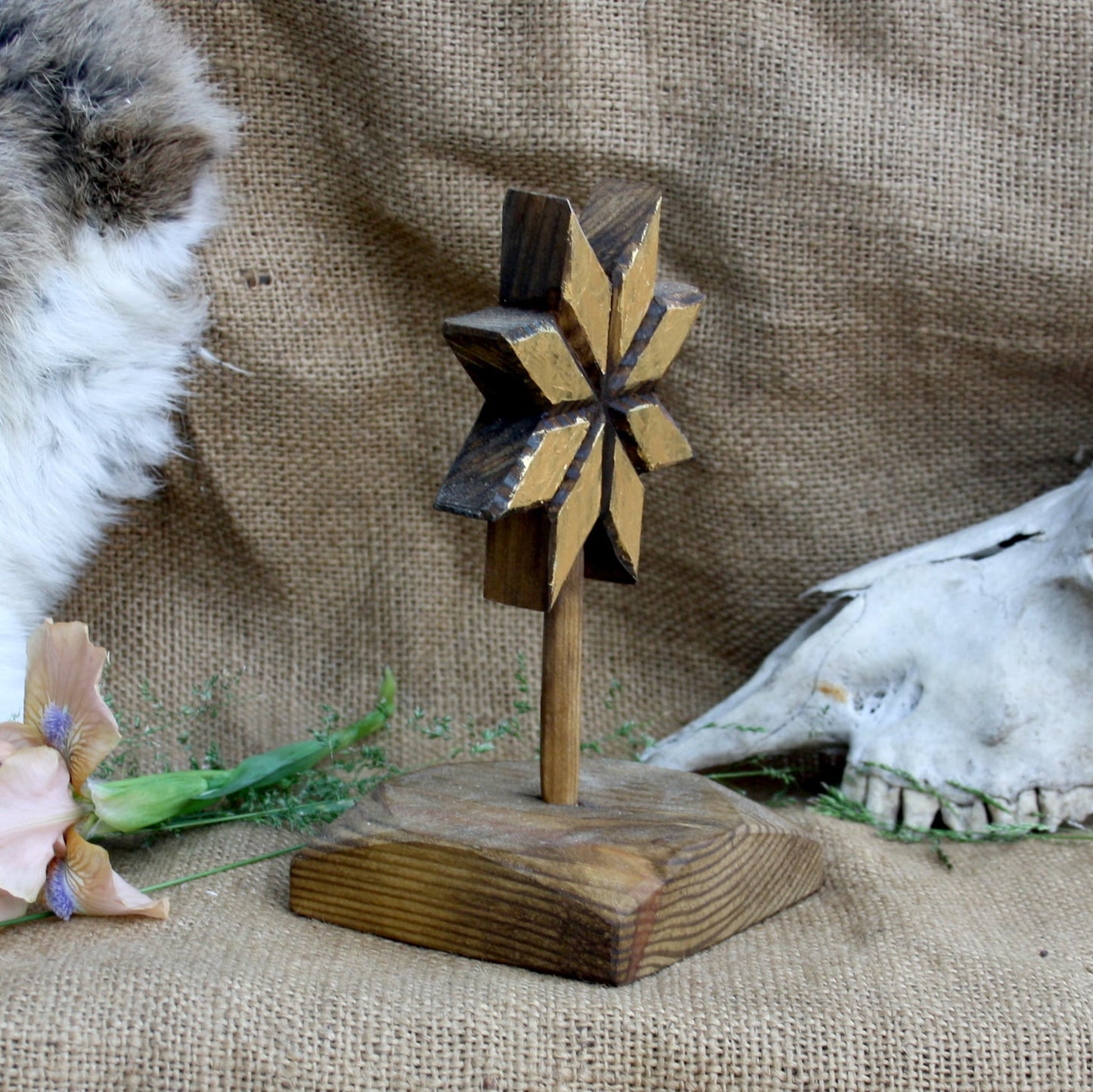 Angled view of handmade wooden Alatyr symbol with gold acrylic finish