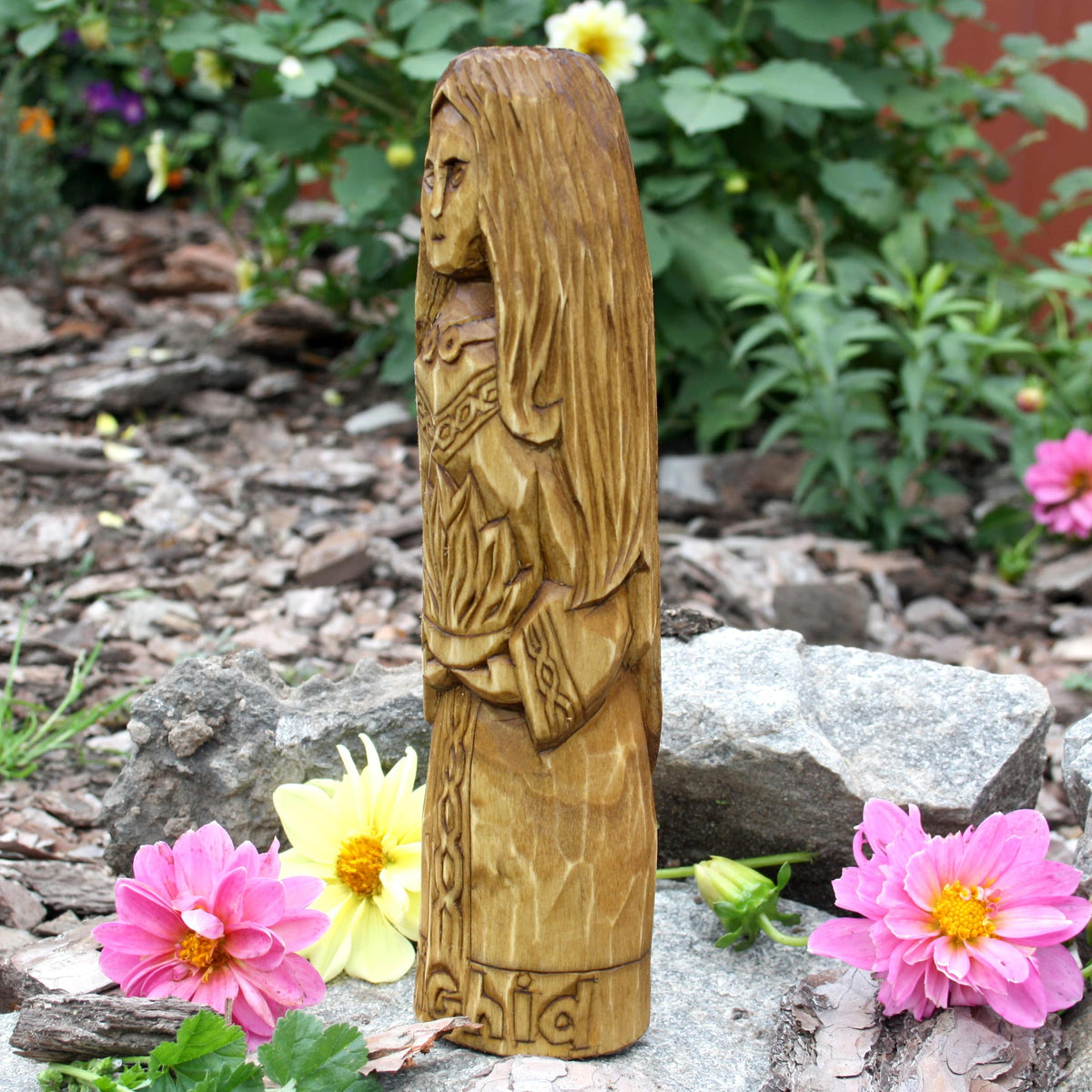 Side profile of the Brigid Celtic goddess statue with carved clothing and flowing hair