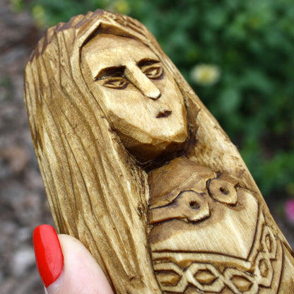 Close-up of Brigid's carved face and long hair on the wooden Celtic goddess statue