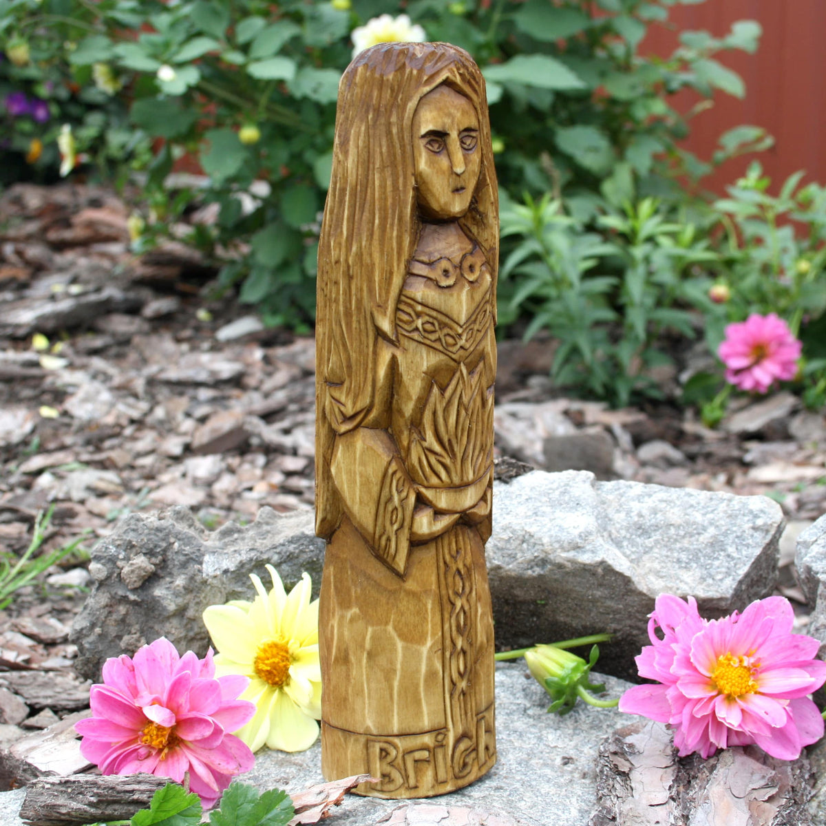 Side view of the Brigid wooden sculpture showing her profile and carved hair