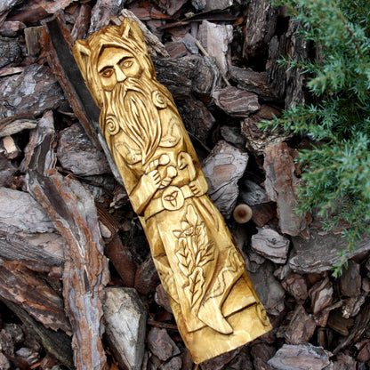 Cernunnos wooden sculpture displayed on natural bark with its antlers visible