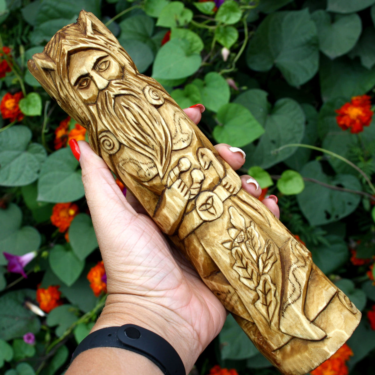 Hand holding the Cernunnos wooden statue to show its size and carved details
