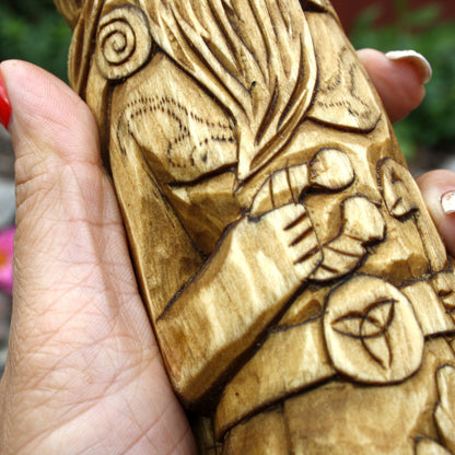 Detailed carved patterns on the clothing of the Cernunnos wooden figure