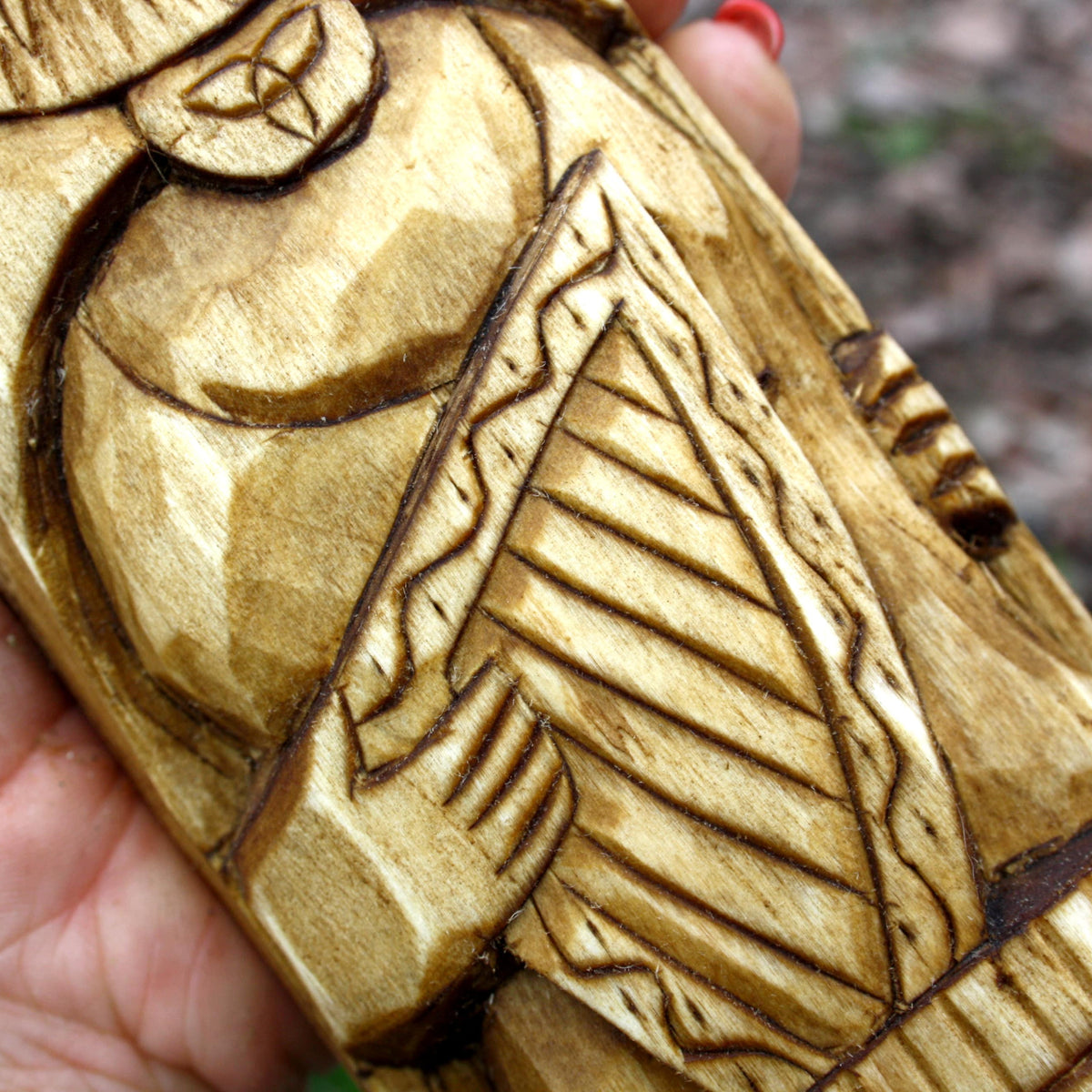 Detailed view of the carved garments and geometric patterns on the Dagda figure
