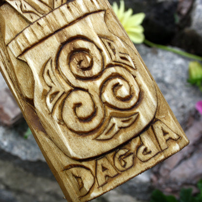 Close-up of the carved spiral motifs and decorative patterns on the Dagda statue base