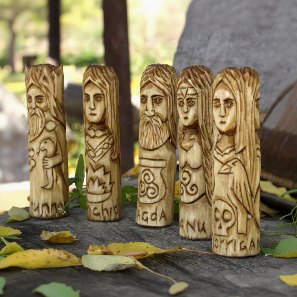 Angled view of five Celtic deity figurines carved from natural linden wood