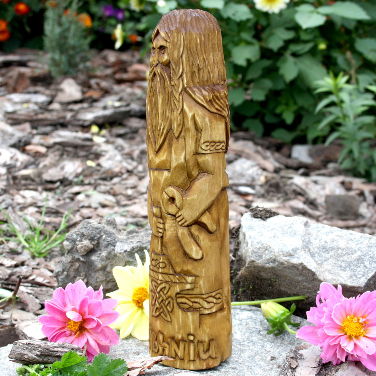 Side view of the Goibhniu statue highlighting its sculpted hair and ornamental details