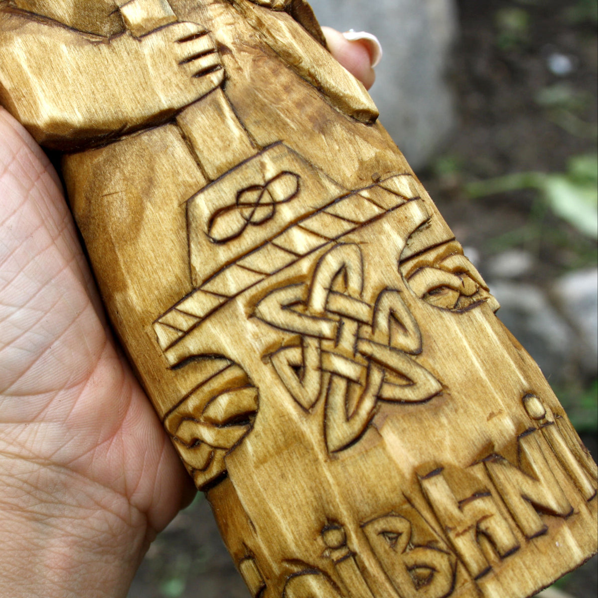 Detailed view of the carved symbols and ornamental patterns on the Goibhniu statue