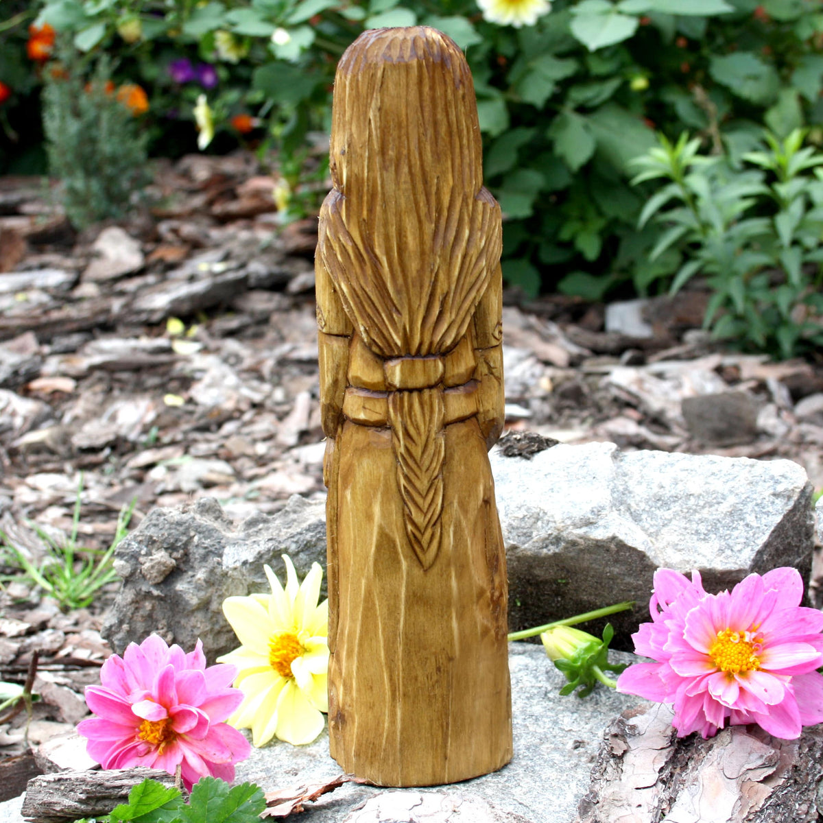Back view of the hand-carved Goibhniu statue showing the natural wood grain
