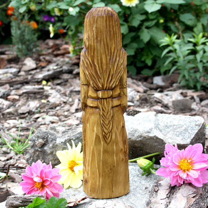 Back view of the hand-carved Goibhniu statue showing the natural wood grain