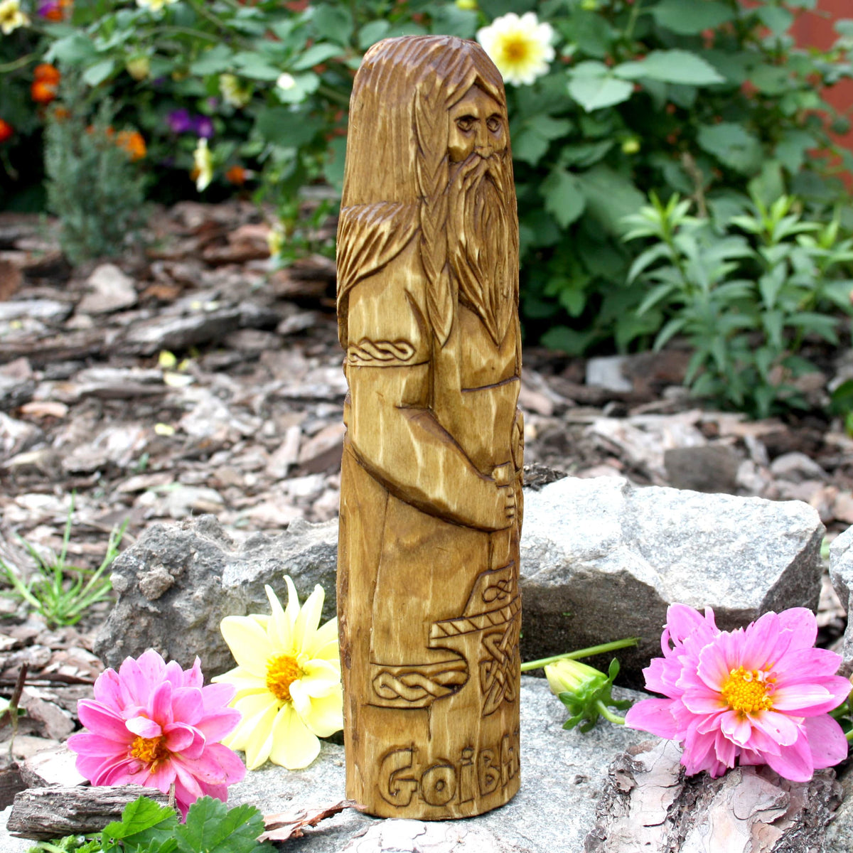 Side profile of the Goibhniu wooden sculpture showing the carved beard and body