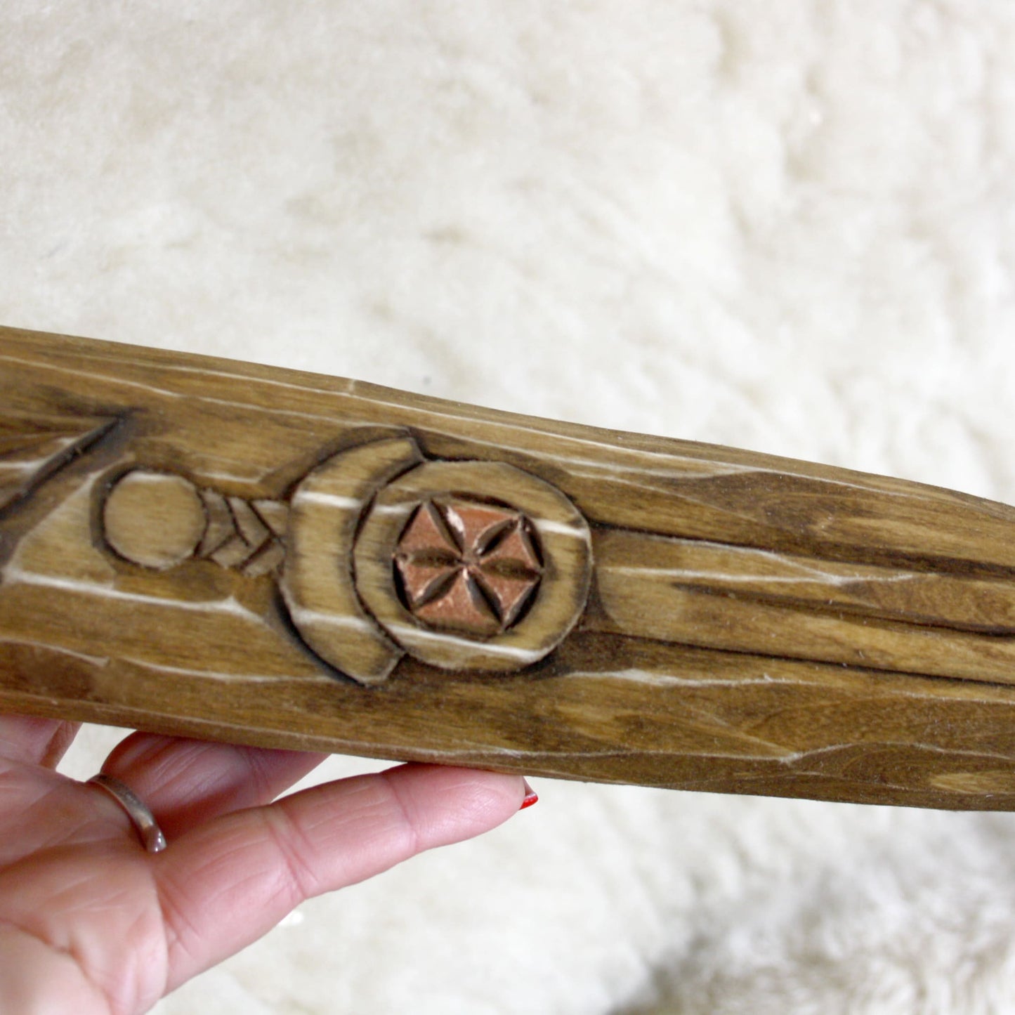 Close-up of carved Kolovrat symbol on Perun wooden ritual staff