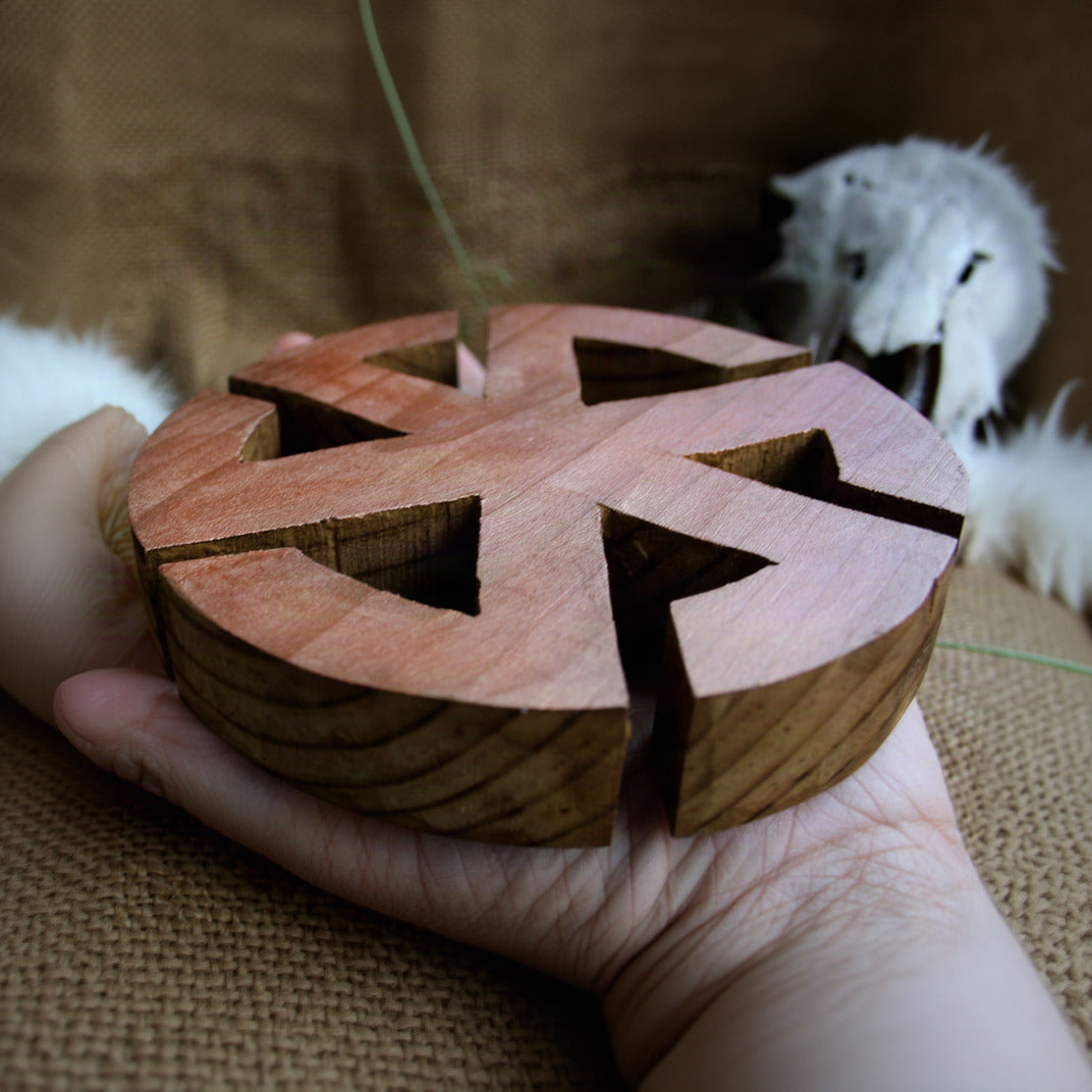 Side profile of wooden Kolovrat symbol showing 2.5 cm thickness in hand