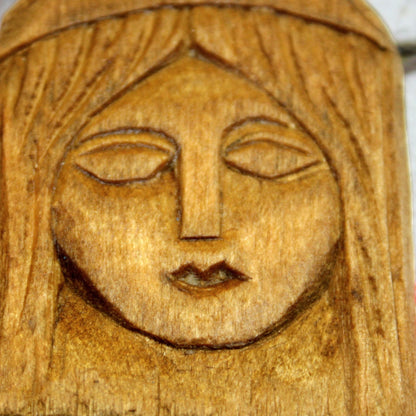 Close-up of handmade Lada wooden amulet with carved details