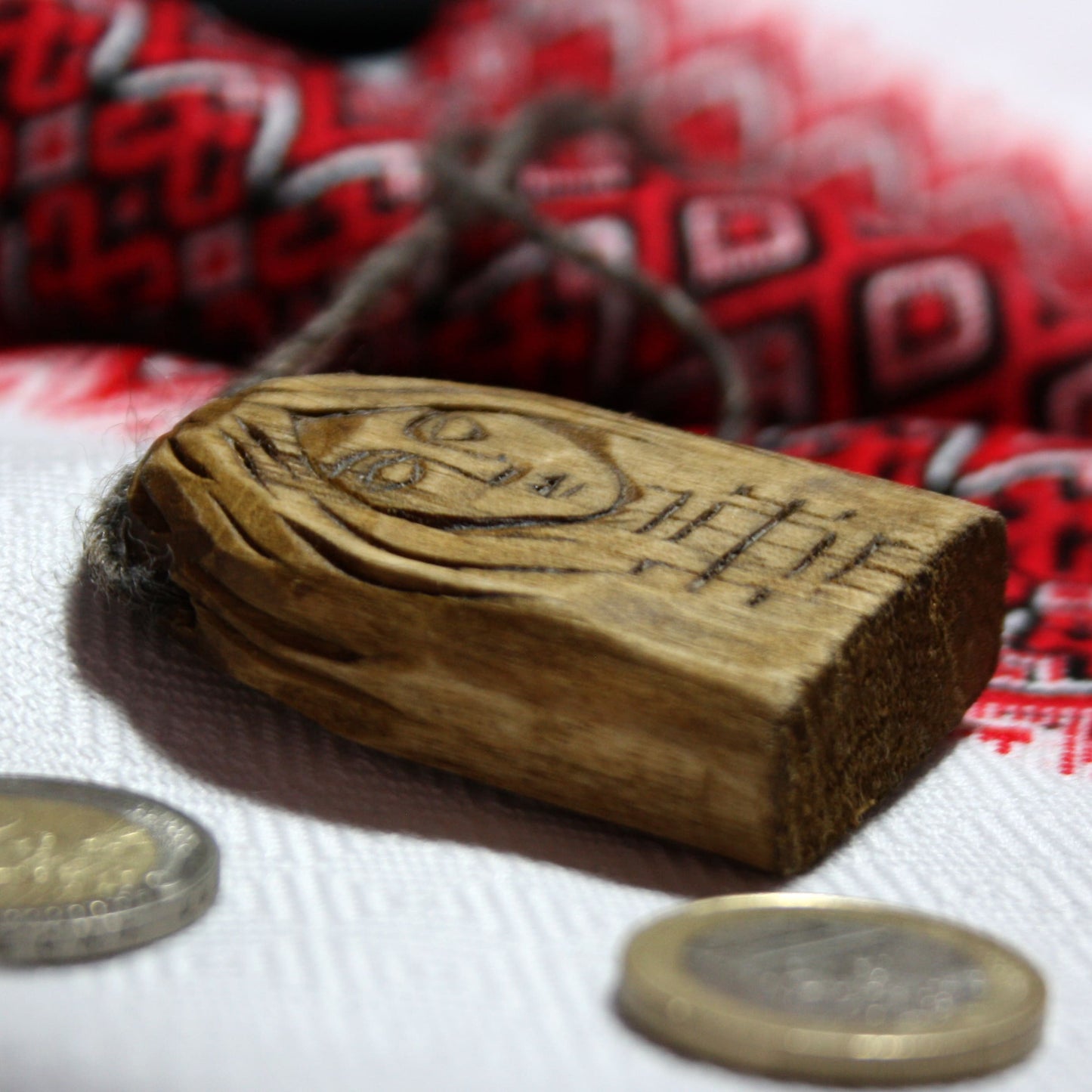 Side view of hand carved Makosh pendant showing its thickness