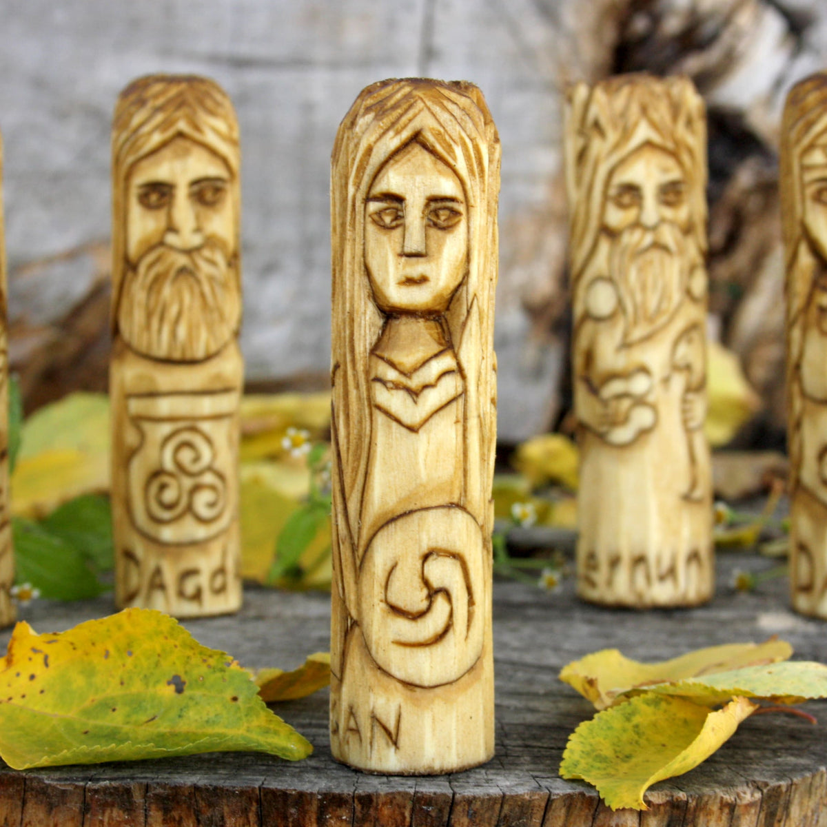 Side view of the Morrigan wooden figurine revealing a different carved face
