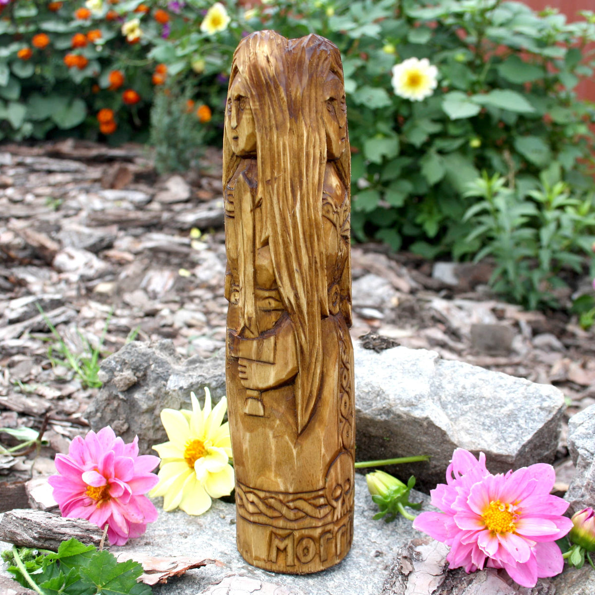 Detailed side view of the triple-body Morrigan statue with carved ornamental patterns