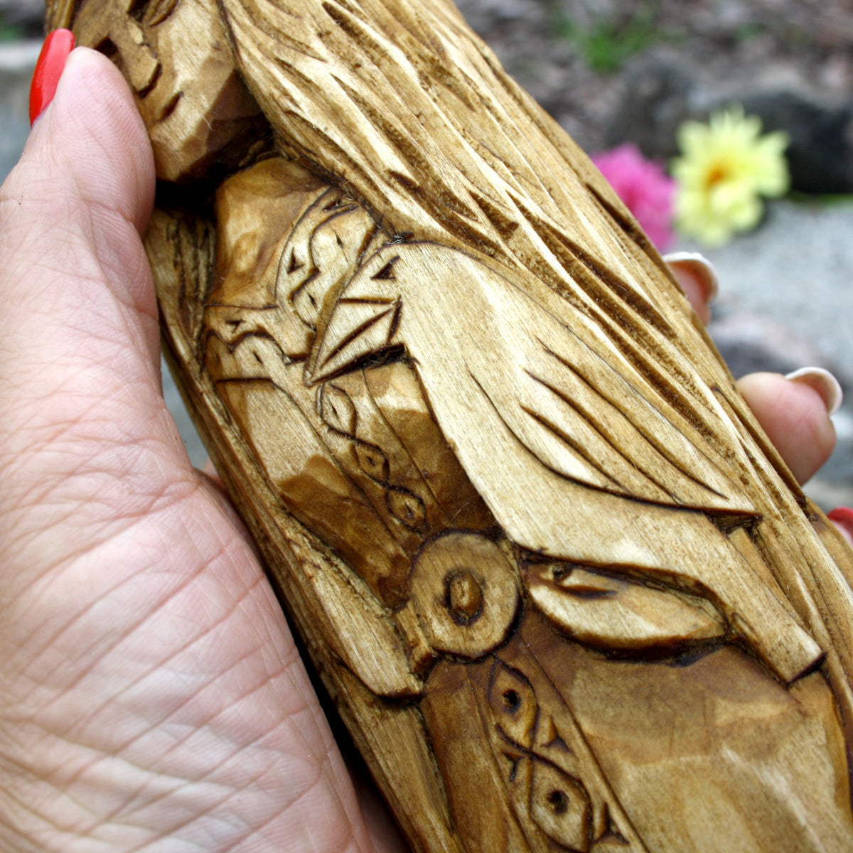 Close-up detail of the triple-form Celtic goddess statue with carved garments and decorative symbols
