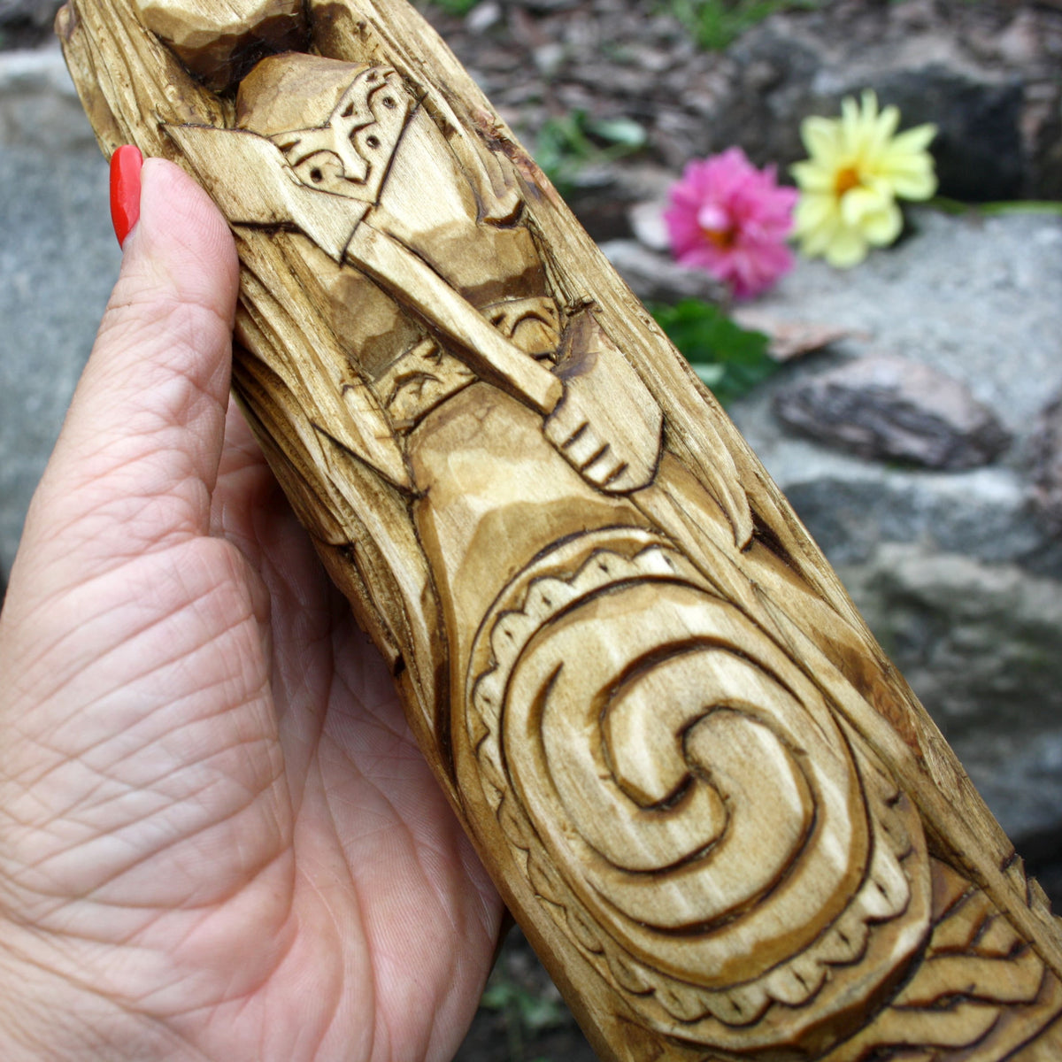 Close-up of the Morrigan statue showing spiral ornament and detailed wood carving