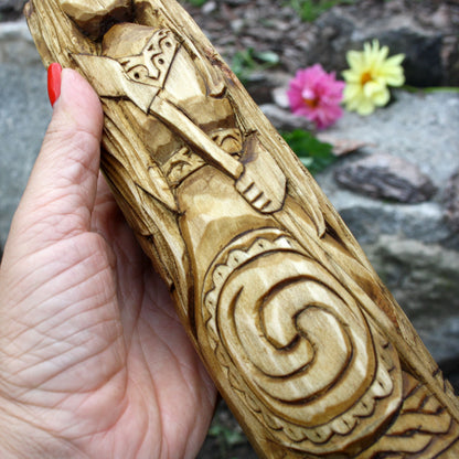 Close-up of the Morrigan statue showing spiral ornament and detailed wood carving