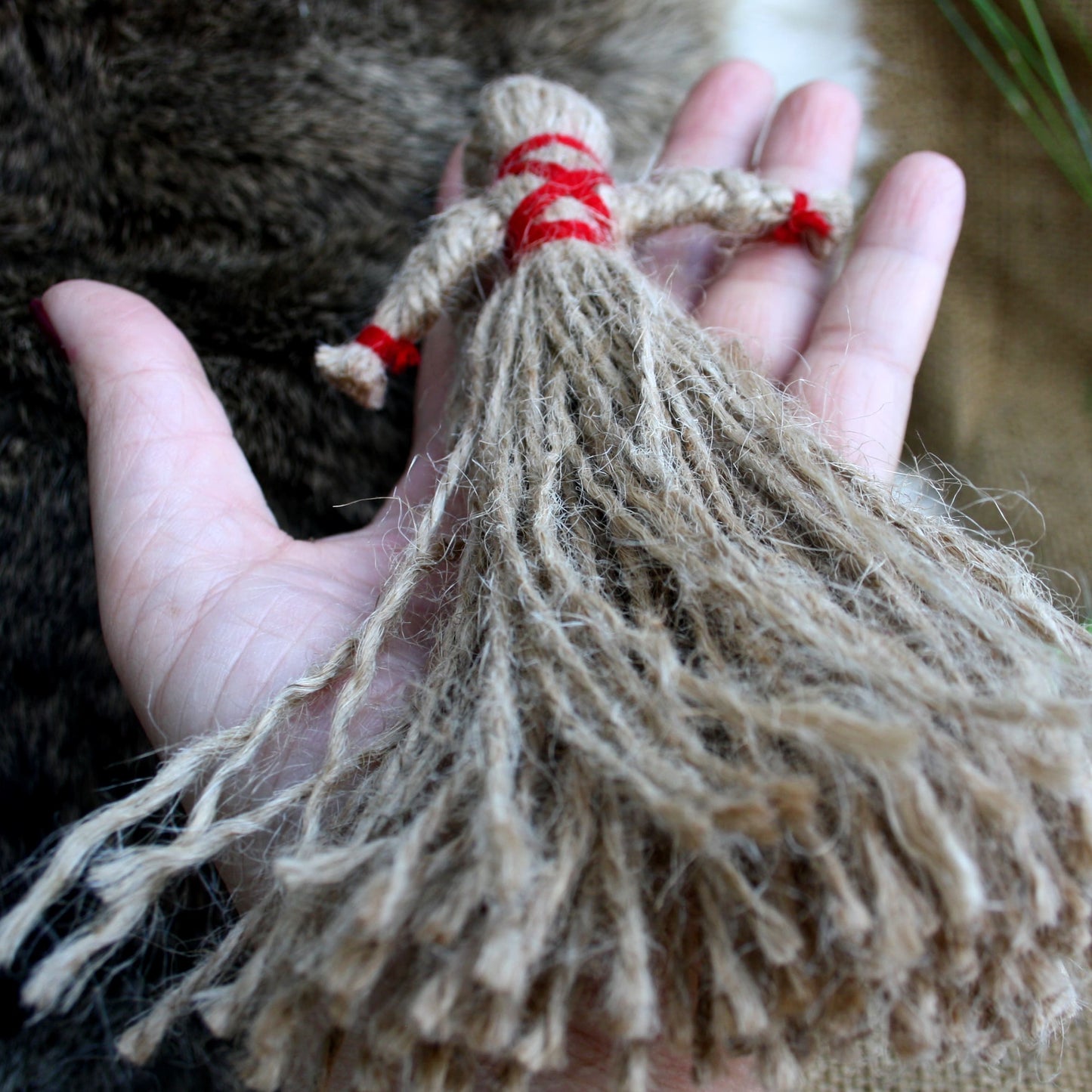 Hand holding Ukrainian Motanka Doll showing its size