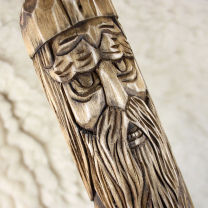 Close-up of Perun face carving on wooden staff