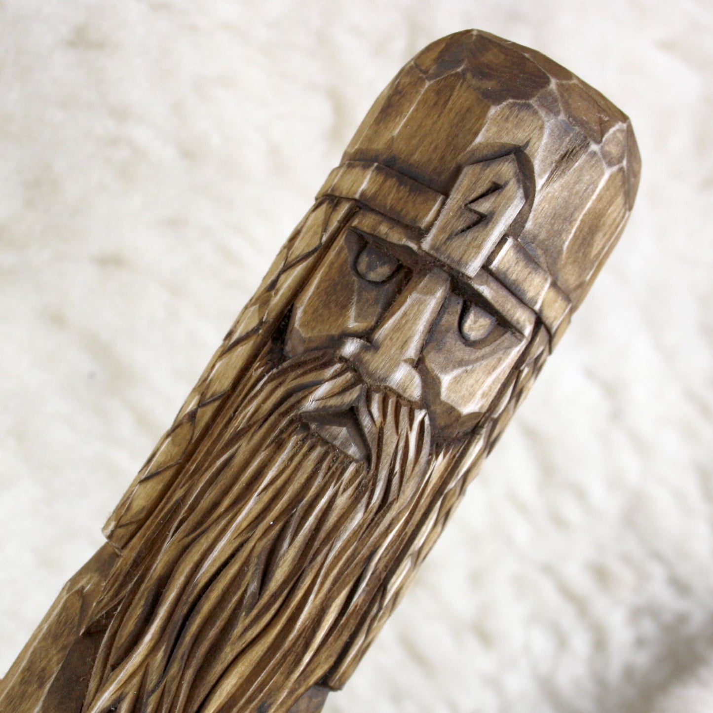 Close-up of Perun face carved into natural linden wood