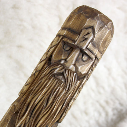 Close-up of Perun face carved into natural linden wood