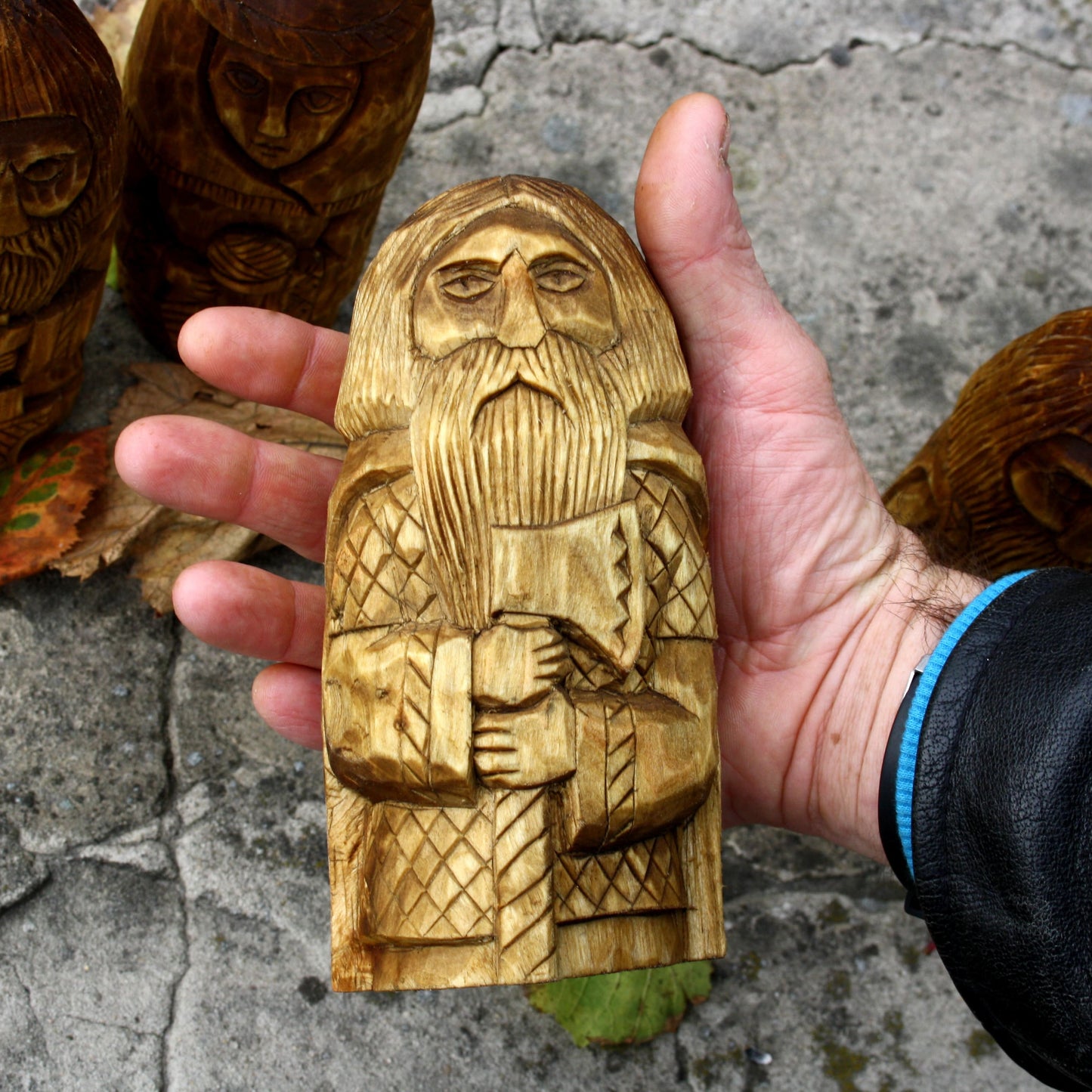 Slavic wooden god figurine held in hand showing 16–17 cm size and scale