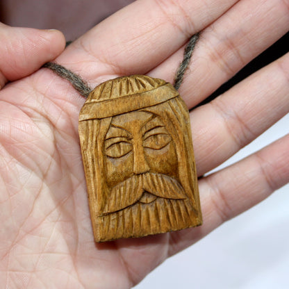 Svarog wooden pendant shown in hand for size comparison