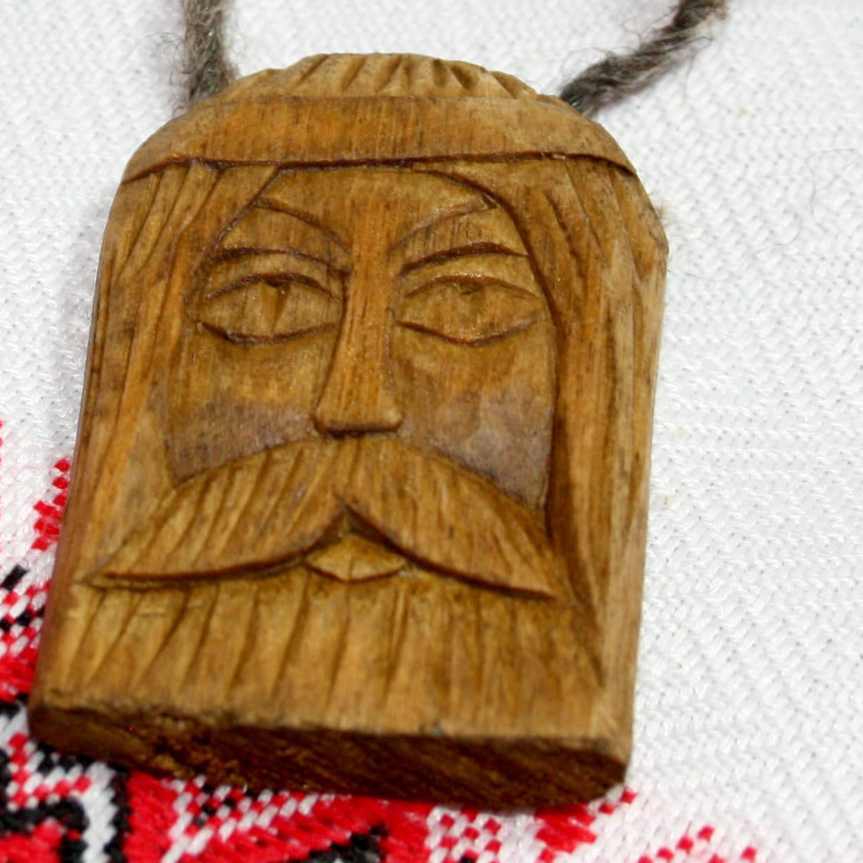 Close-up of handmade Svarog wooden amulet with carved details
