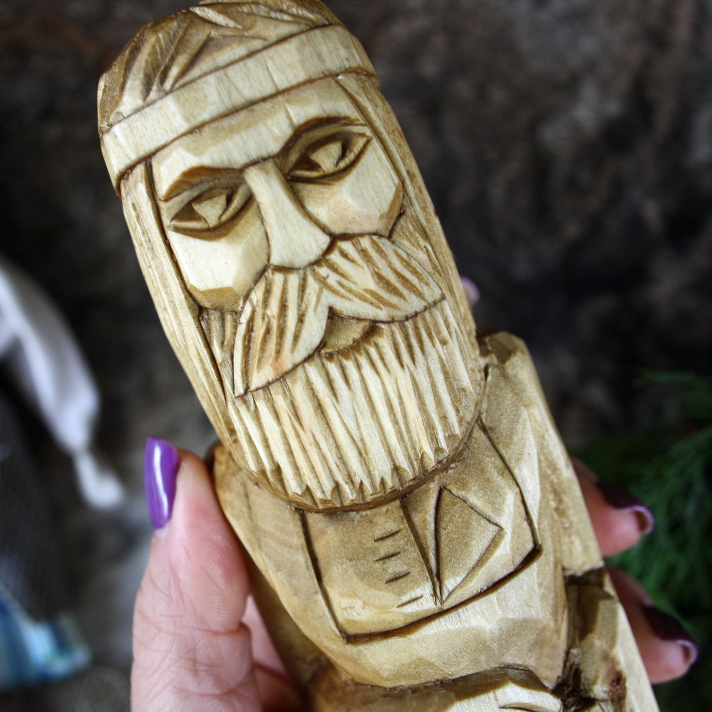 Close-up of Svarog Slavic God face hand carved wooden statue