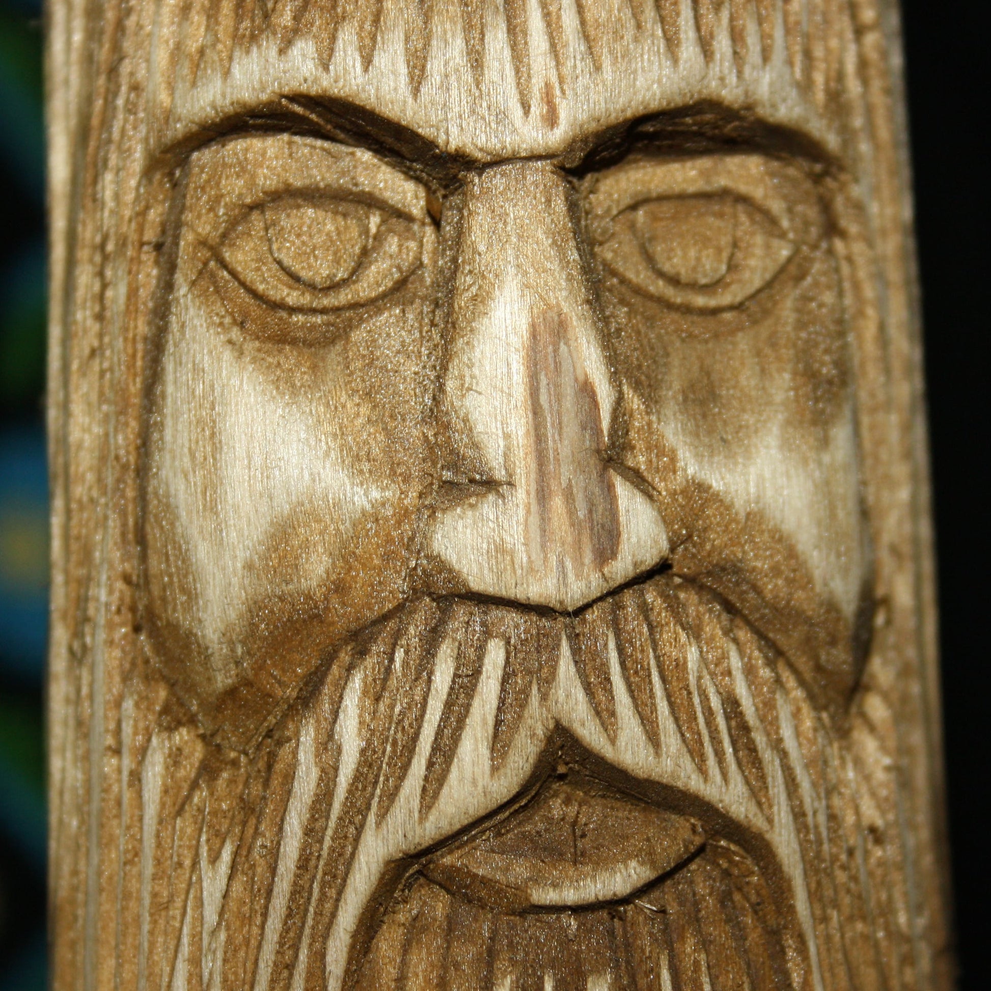 Close-up of Veles Slavic God face hand carved wooden idol