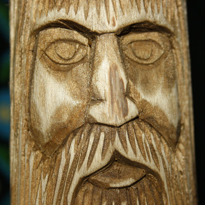 Close-up of Veles Slavic God face hand carved wooden idol