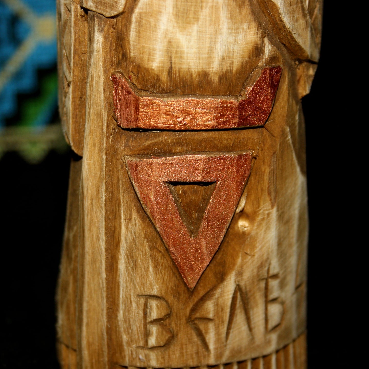 Detailed carving of Veles symbol on wooden idol